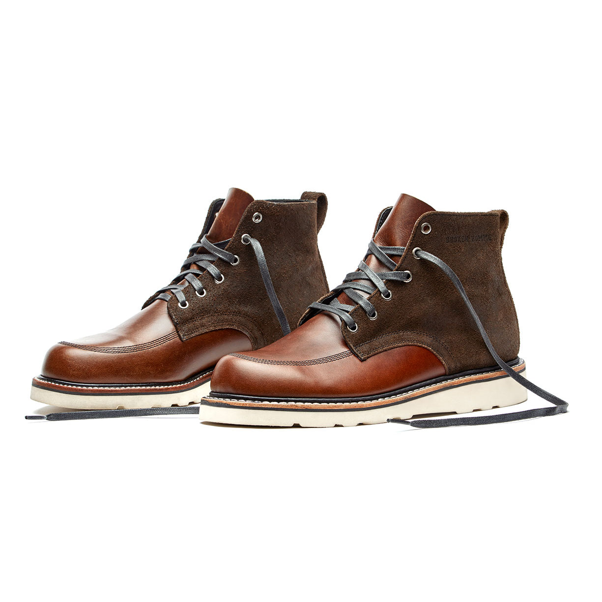 A comfortable fit pair of Broken Homme Jaime Boots, in a combination of brown and tan colors, placed on a white background.