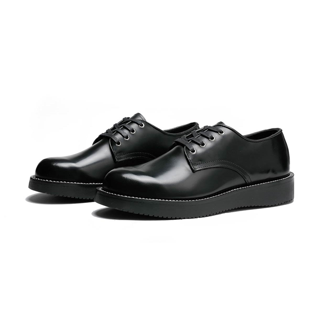 A pair of black Michael derby shoes by Broken Homme with leather uppers and a vibram wedge outsole on a white background.