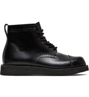 A black leather pair of Aaron boots from the Broken Homme collection featuring a cap toe silhouette, set against a clean white background.