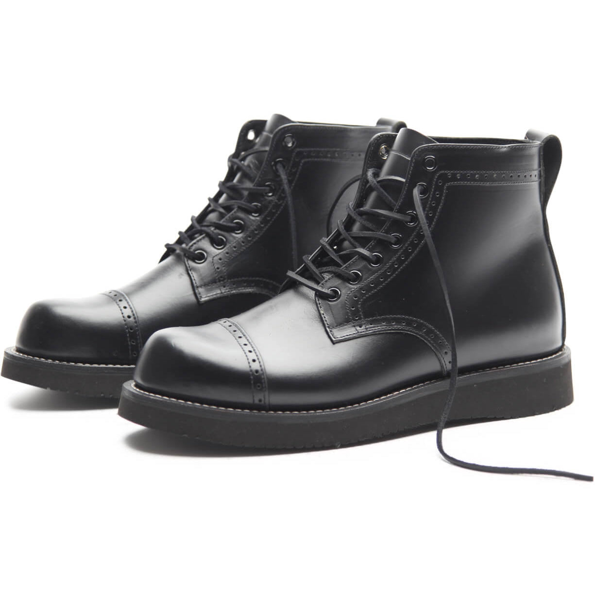 The Broken Homme Aaron Boot, a sleek and stylish addition to the Broken Homme collection, showcases a cap toe silhouette. These black boots stand out on a crisp white background.