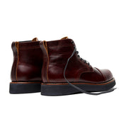 A pair of men's Broken Homme Aaron Boots in burgundy leather with a cap toe silhouette.