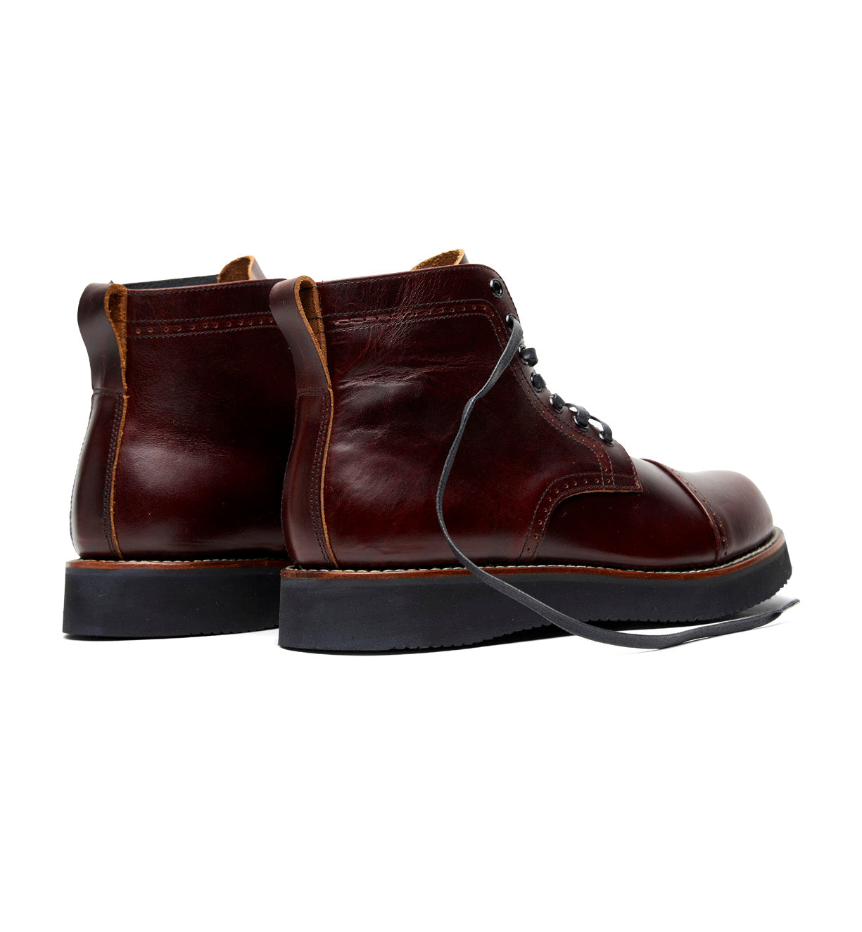 The Broken Homme Aaron Boot in burgundy leather features a classic cap toe silhouette.