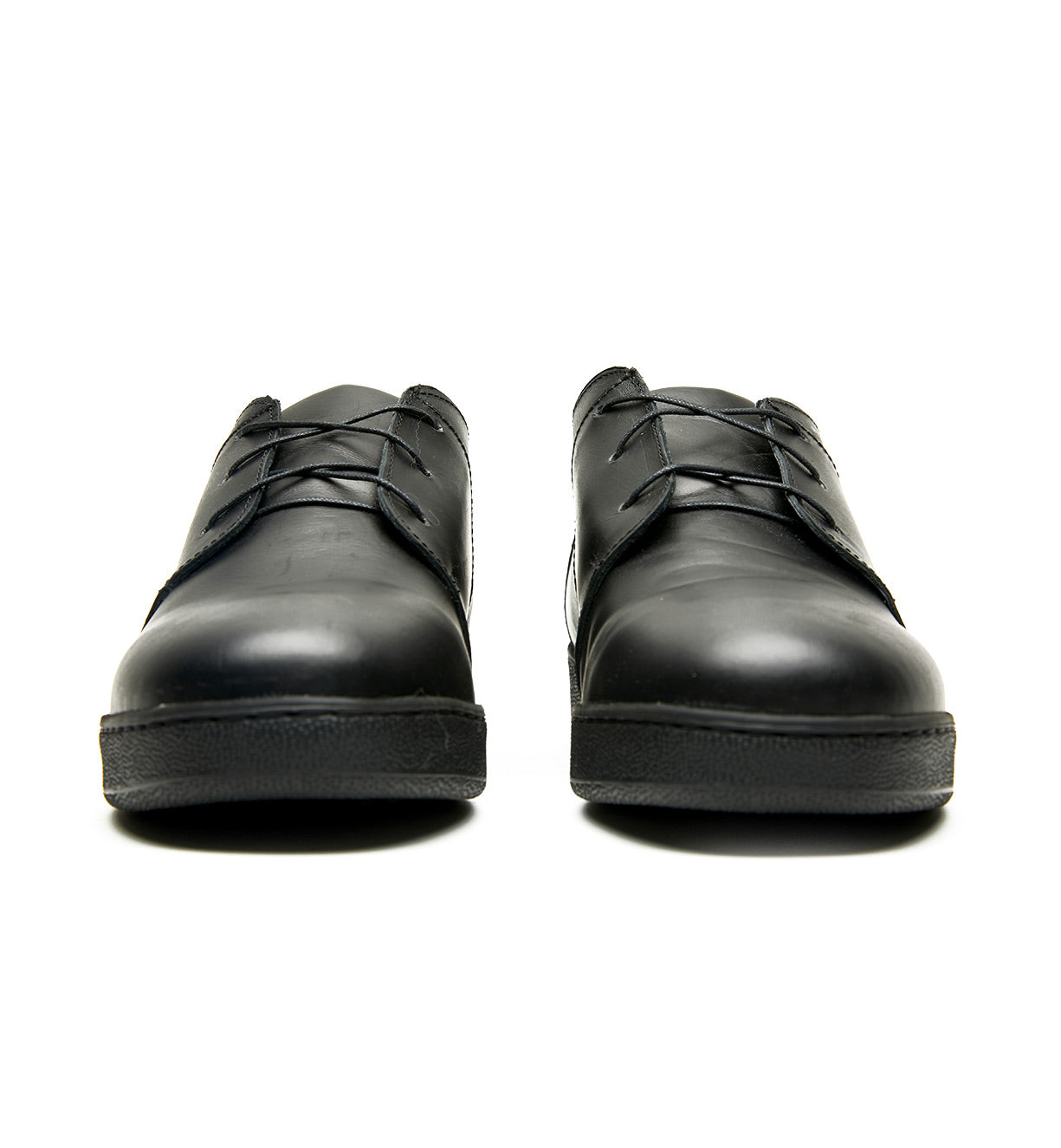 A pair of Broken Homme Ben Low black leather shoes with a cork filled midsole on a white background.