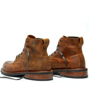 A pair of Broken Homme Davis II brown leather work boots on a white background.