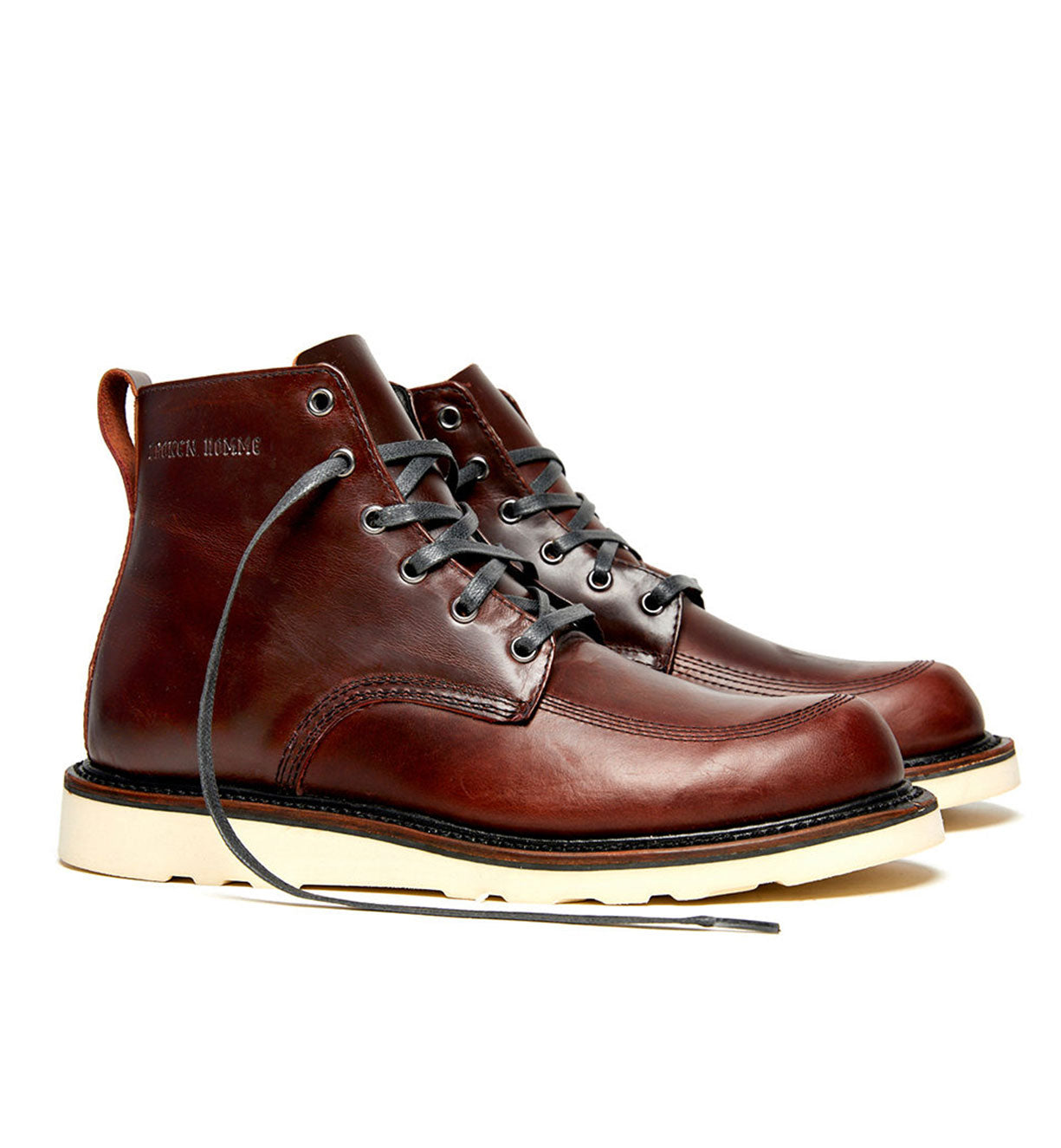 A pair of brown leather Broken Homme Jaime Boots with laces and a natural wedge.