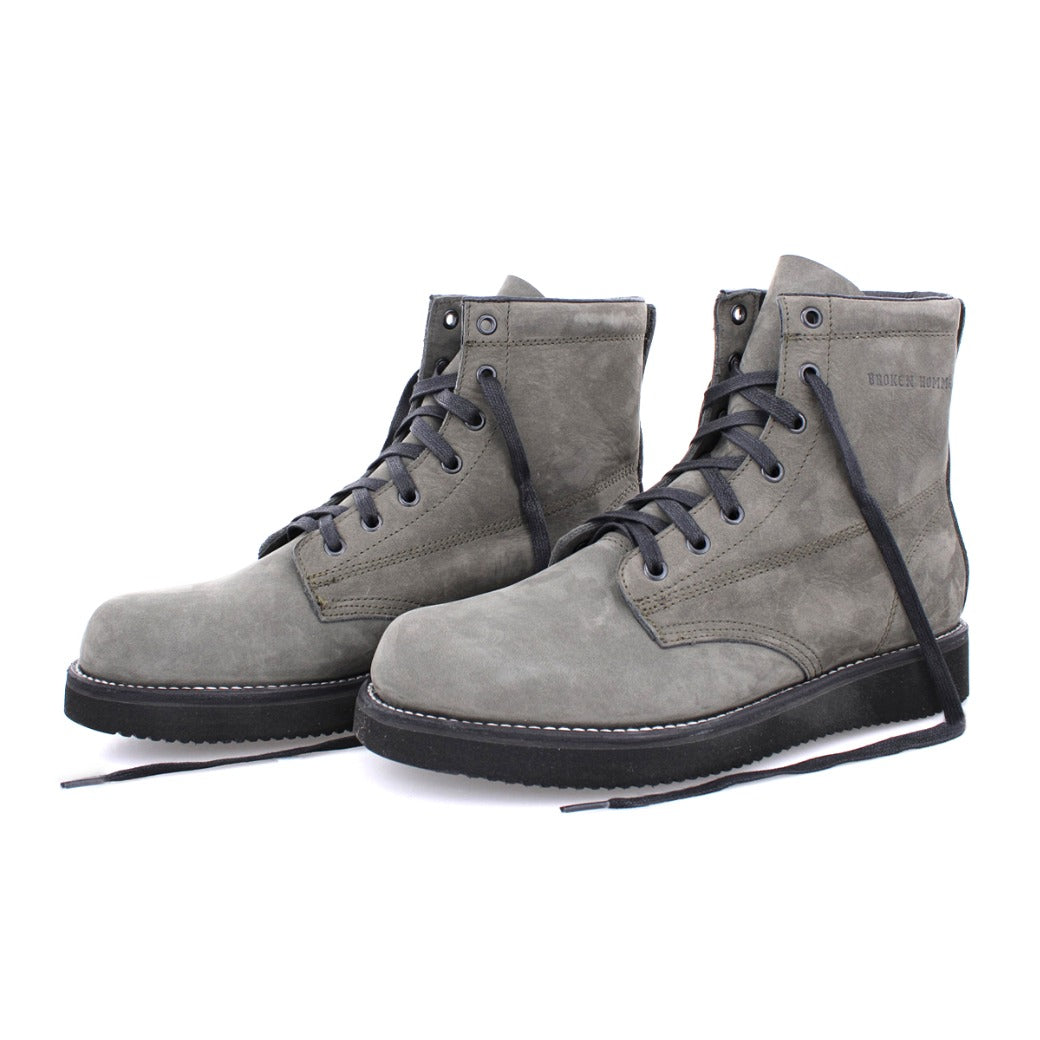 A pair of James Boots from the Broken Homme collection, featuring black laces and a sleek grey design.