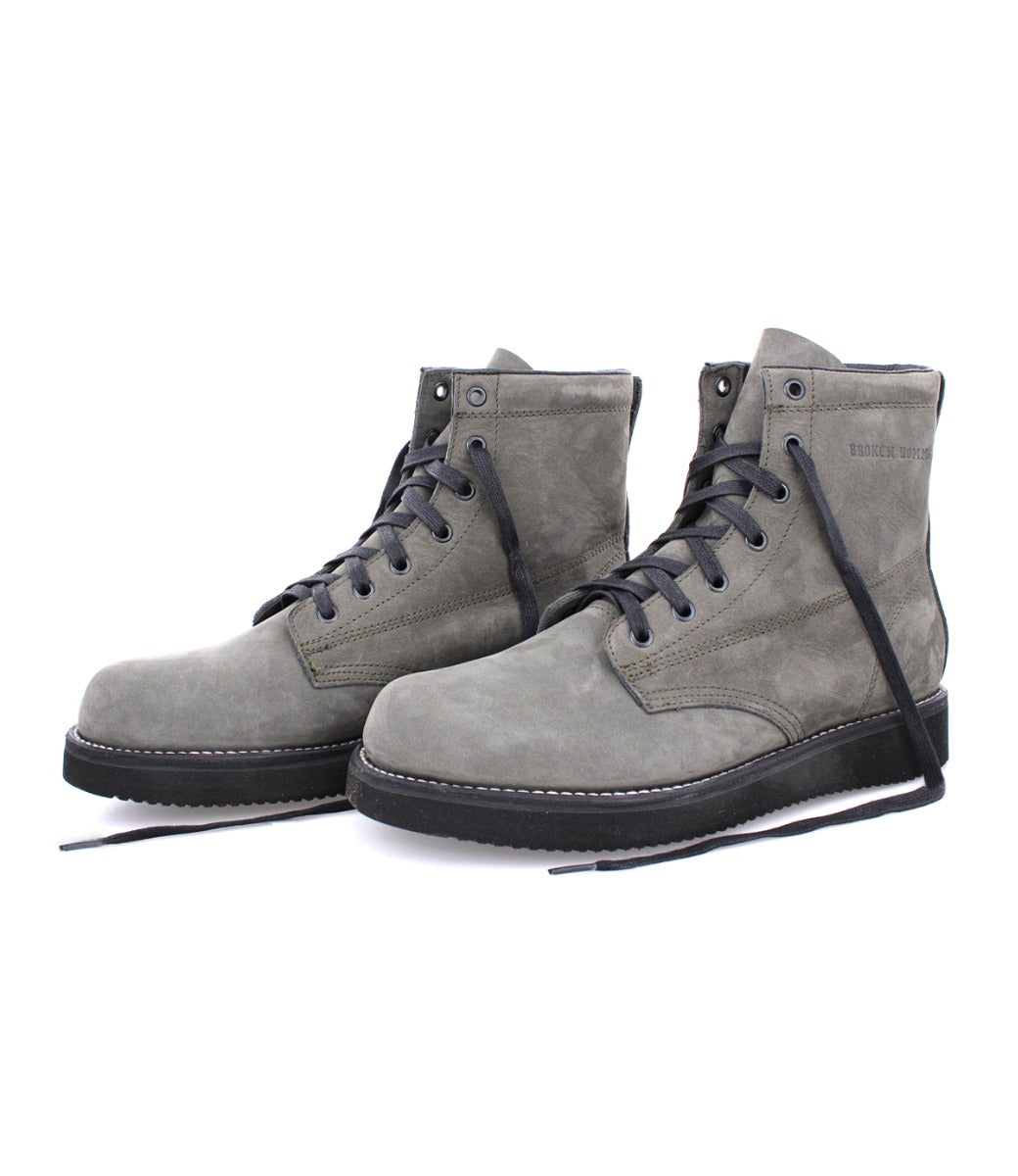 A pair of James Boots from the Broken Homme collection, featuring black laces and a sleek grey design.