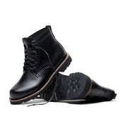 A pair of Tydus black full grain leather boots by Broken Homme with a refined style on a white background.